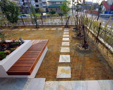 芝生の中に埋められた40センチ角の天然石の平板。春にはもっと美しい色相いに変わります。